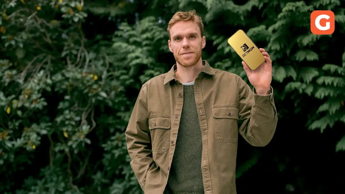 Connor McDavid holding a phone displaying the BetMGM logo