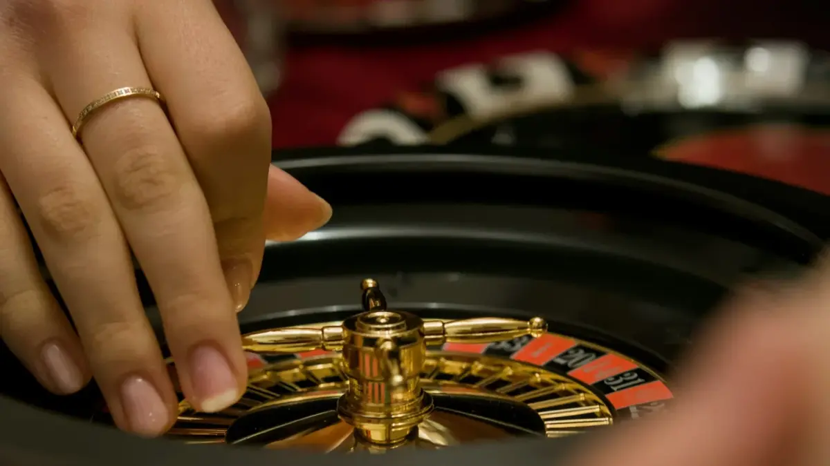 Dealer spinning a roulette wheel at a live casino table