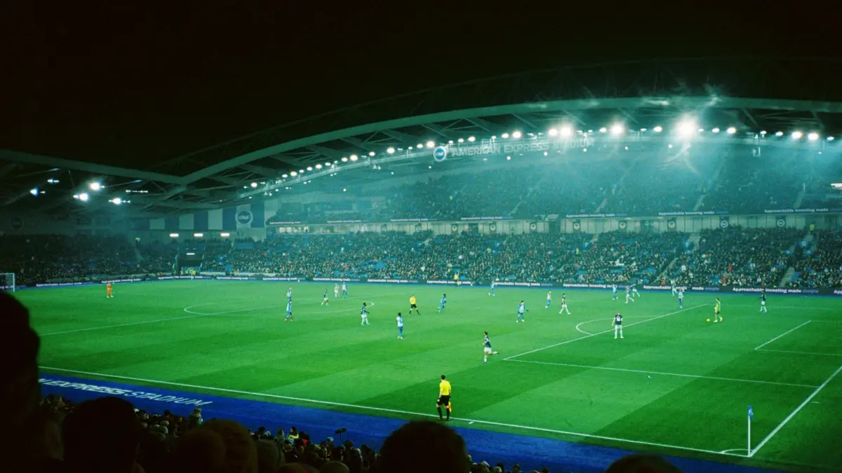 Floodlit football stadium during a night match