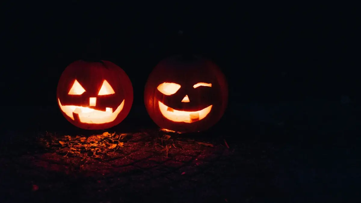 Two lit jack-o’-lanterns at night