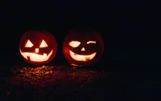 Two lit jack-o’-lanterns at night