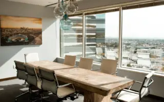 Empty boardroom with a long wooden conference table and a city view