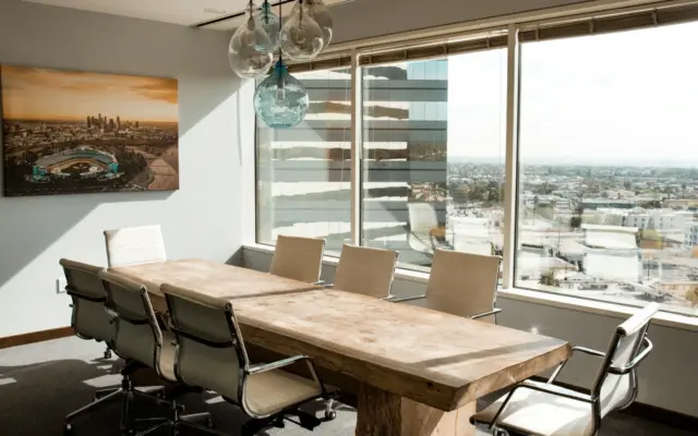 Empty boardroom with a long wooden conference table and a city view
